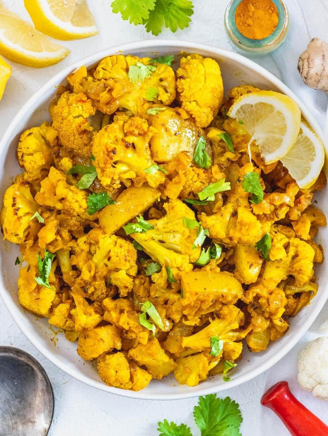 Aloo Gobi in einer Schale mit Zitronenscheiben