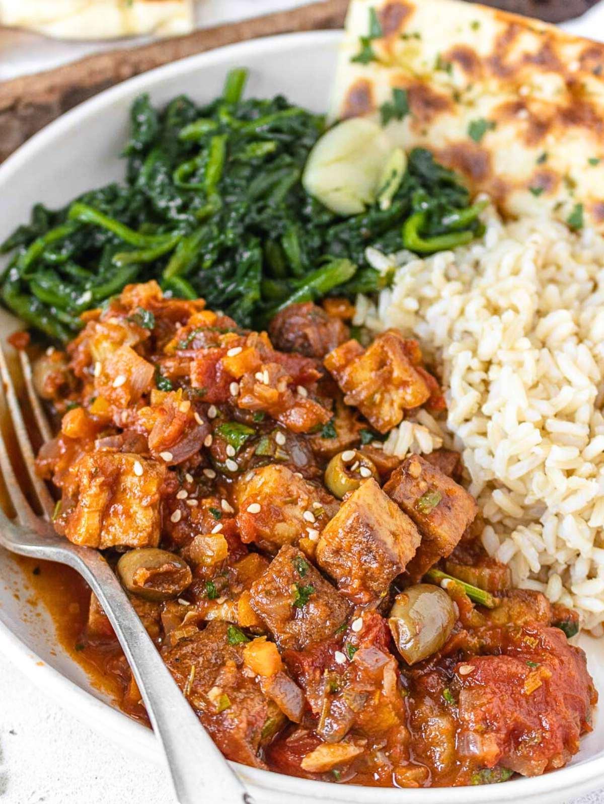 Tofu nach Jägerart 2 tofu cacciatore with a fork and rice.
