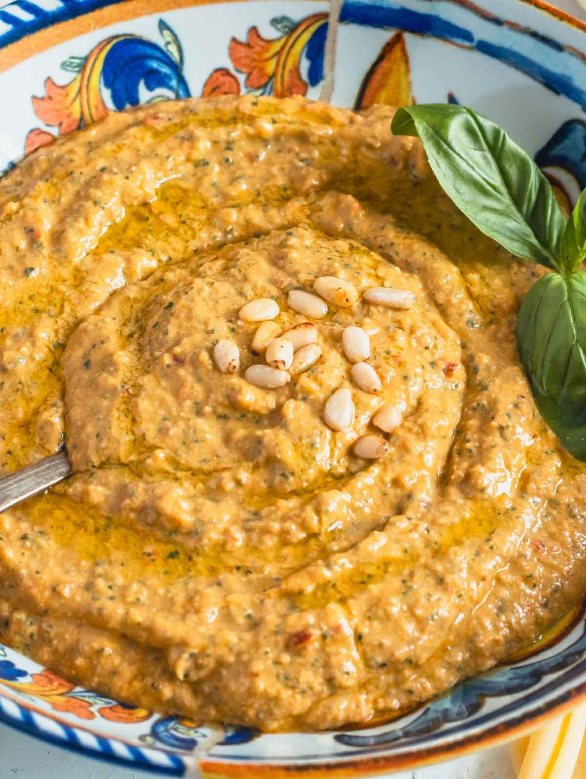 Rotes Pesto in einer Schüssel mit Pinienkernen und frischem Basilikum