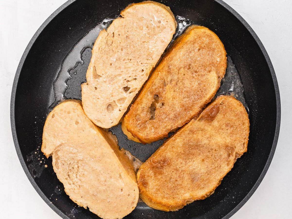 slices of bread frying in a black skillet