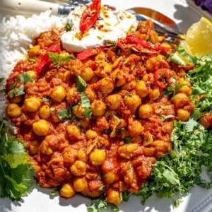 Chana Masala 11 Chana Masala mit Grünkohl und einem Klecks Joghurt auf einem Teller