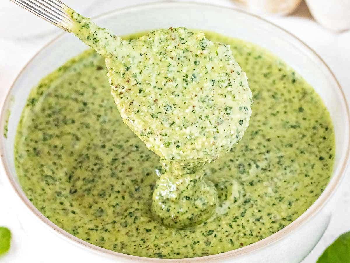 Rucola Pesto mit einem Löffel in einer weißen Schüssel