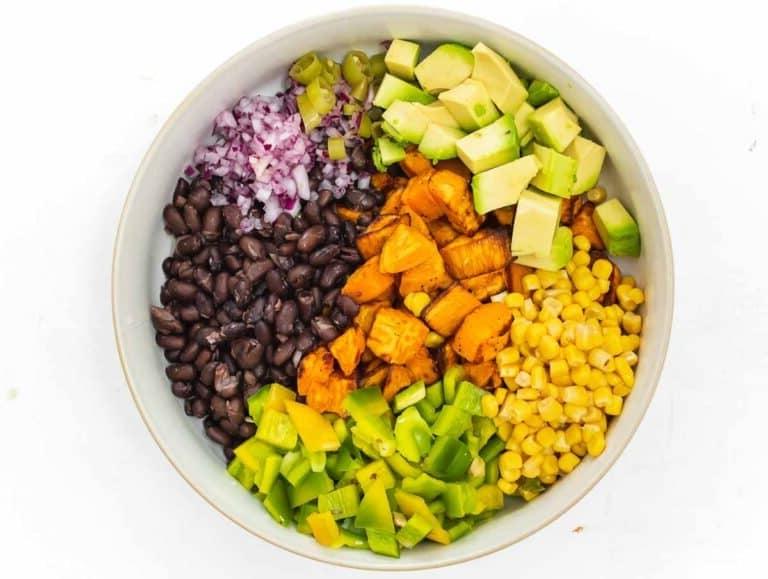 Avocado, Mais, grüner Paprika, schwarze Bohnen, Jalapeño, rote Zwiebel und Süßkartoffeln in einer Schüssel