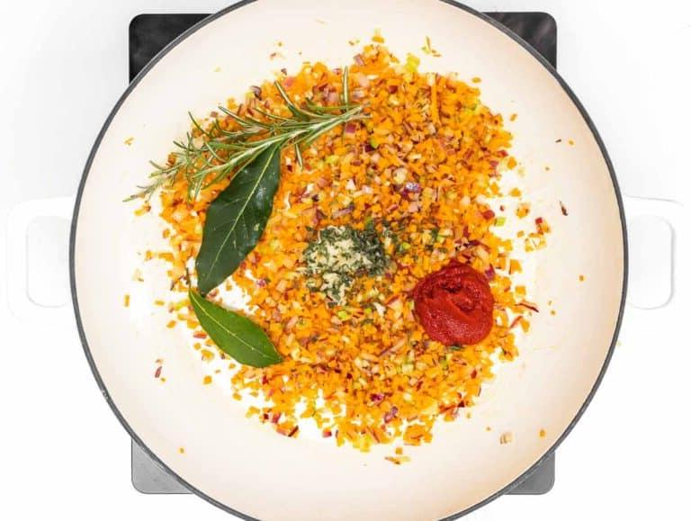 frische Kräuter und Tomatenpüree im Topf