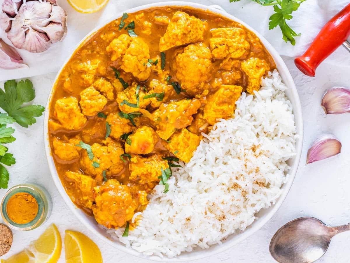 Tofu-Curry serviert mit Basmatireis und Zitronenspalten
