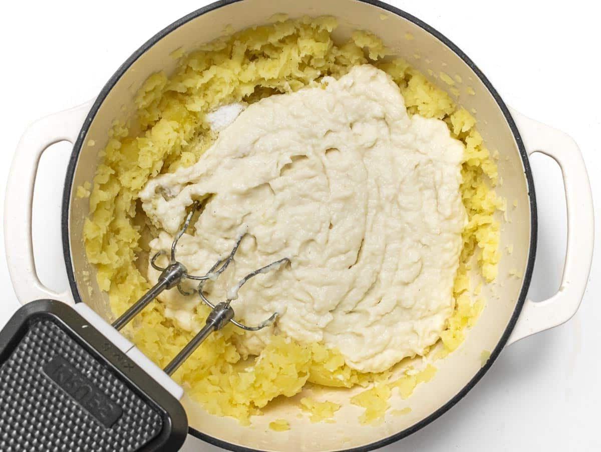 Blumenkohlpüree zu den Kartoffeln geben