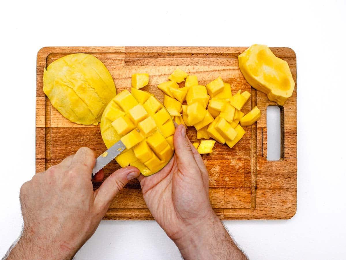 Gewürfelte Mango aus der Schale entfernen