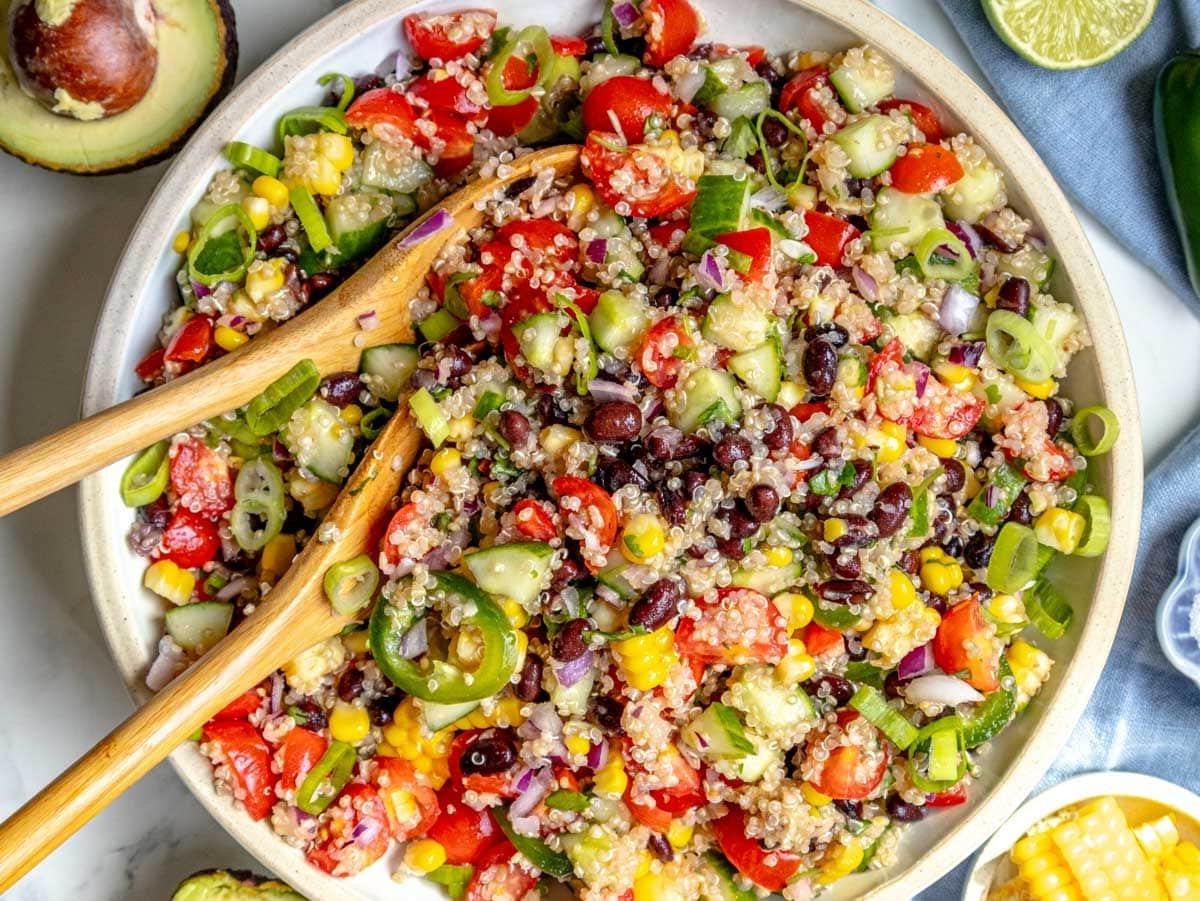 quinoa salad after mixing in a white bowl with corn