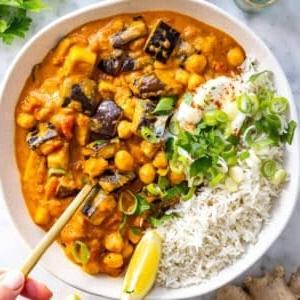 Auberginen-Curry mit Basmatireis, Joghurt und einem Löffel.