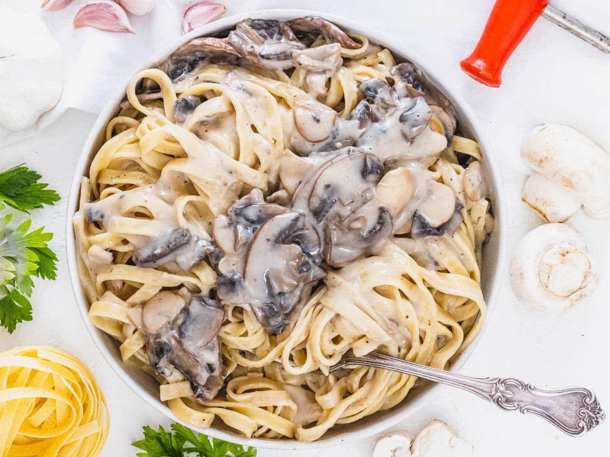 Pilz-Alfredo 13 Mushroom Alfredo in a bowl with a fork