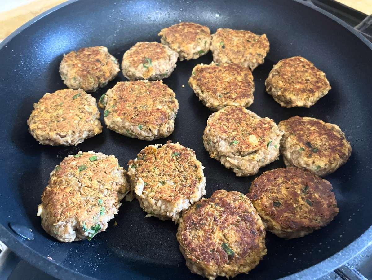 Linsen-Bällchen, die leicht abgeflacht in einer Pfanne liegen.