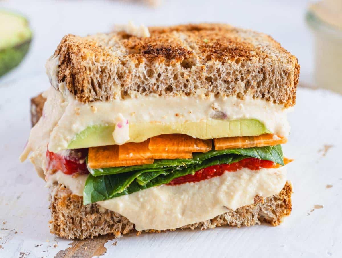 Hummus Sandwich nah auf einem weißen Schneidebrett