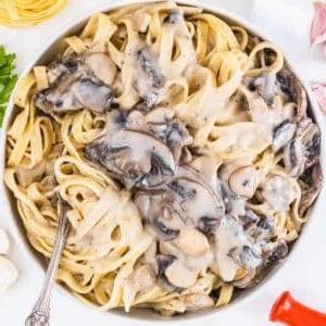 Pilz-Alfredo 14 Mushroom Alfredo Sauce with fettuccine and a silver fork.