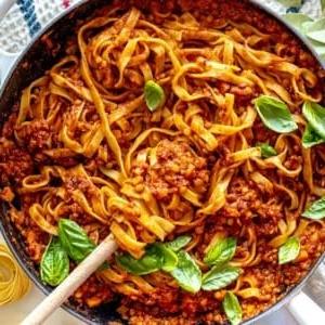 Linsen-Bolognese in einer Pfanne mit frischem Basilikum