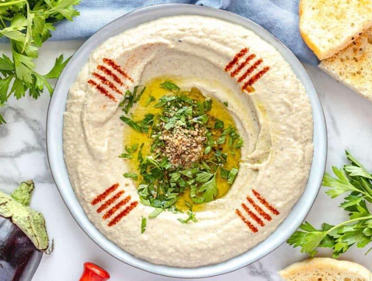 Baba Ganoush auf einem Teller mit Olivenöl, Petersilie und Paprika garniert.