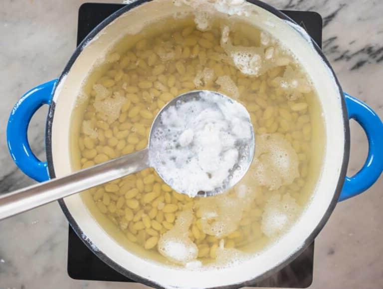 Weißer Schaum im Kochwasser mit weißen Bohnen