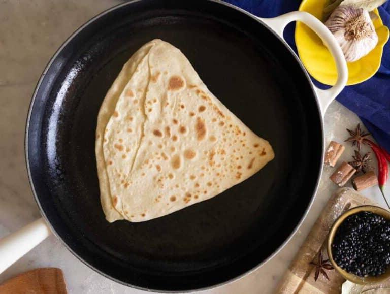 Paratha wird in einer Gusseisenpfanne gekocht.