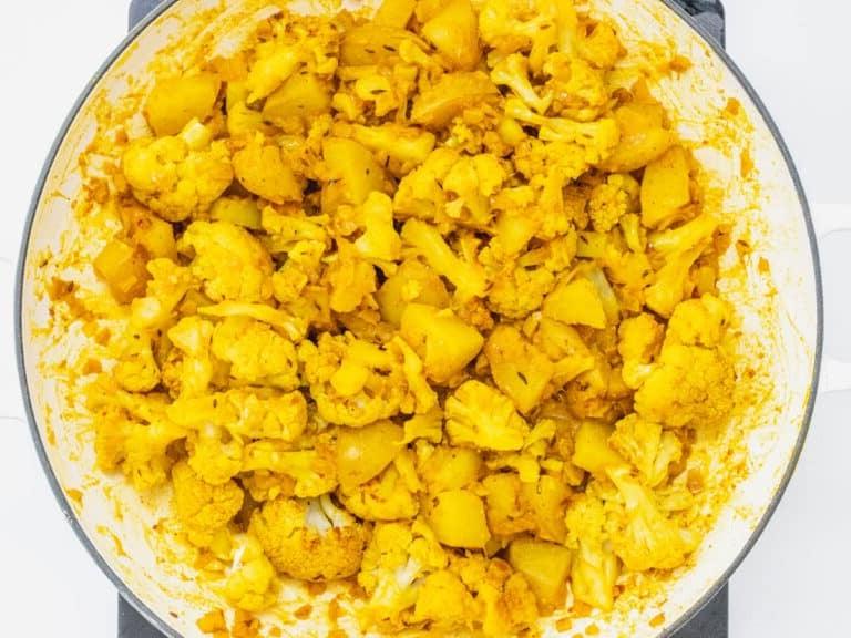 Blumenkohlröschen und Kartoffeln in einer Pfanne