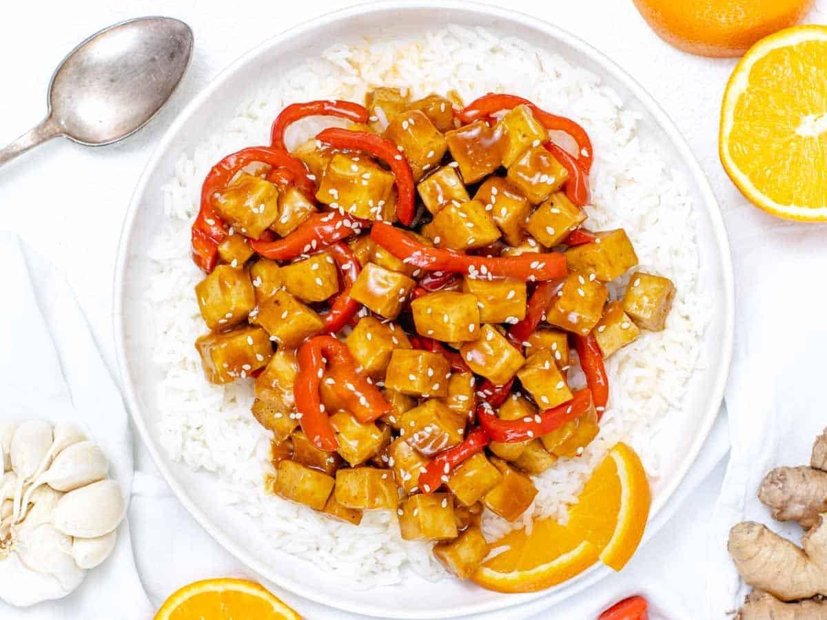 Orangen-Tofu mit Paprika, serviert auf einer Schüssel Reis
