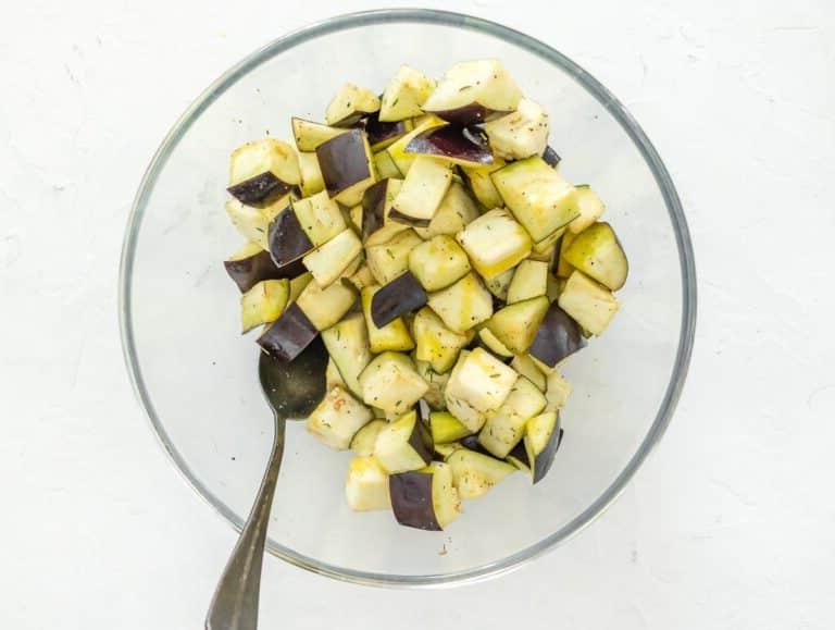 Auberginenwürfel mit Gewürzen vermischen
