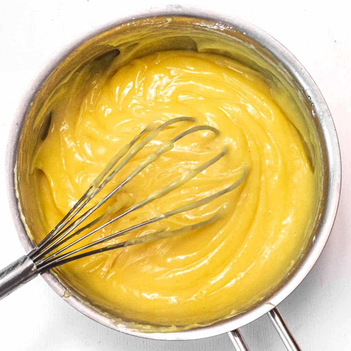 Glänzende, goldgelbe vegane Zitronencreme in einem Glas.