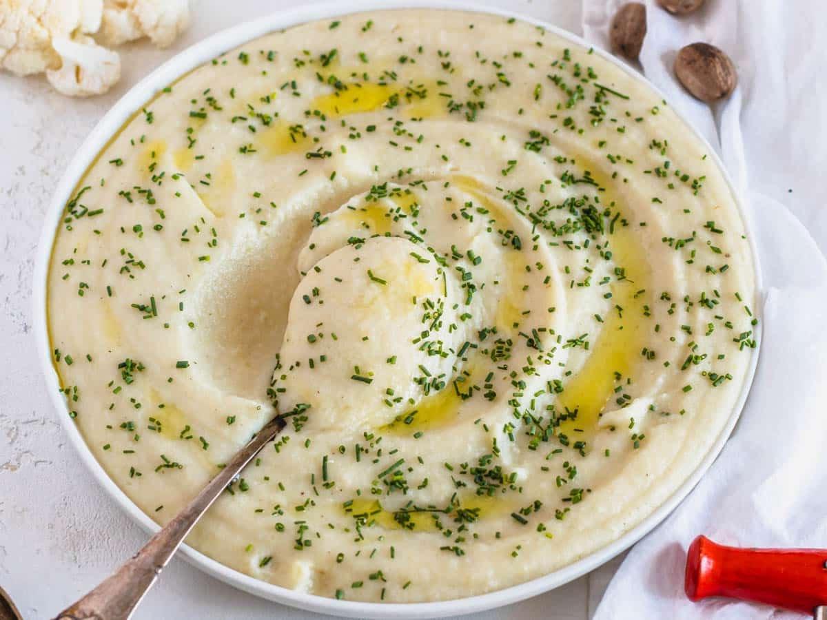 Blumenkohl-Kartoffelpüree mit silbernem Löffel in der Mitte