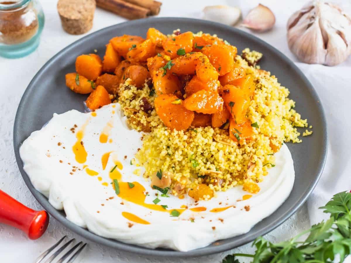 Marokkanischer Couscous serviert mit Joghurt und marokkanischem Karottensalat