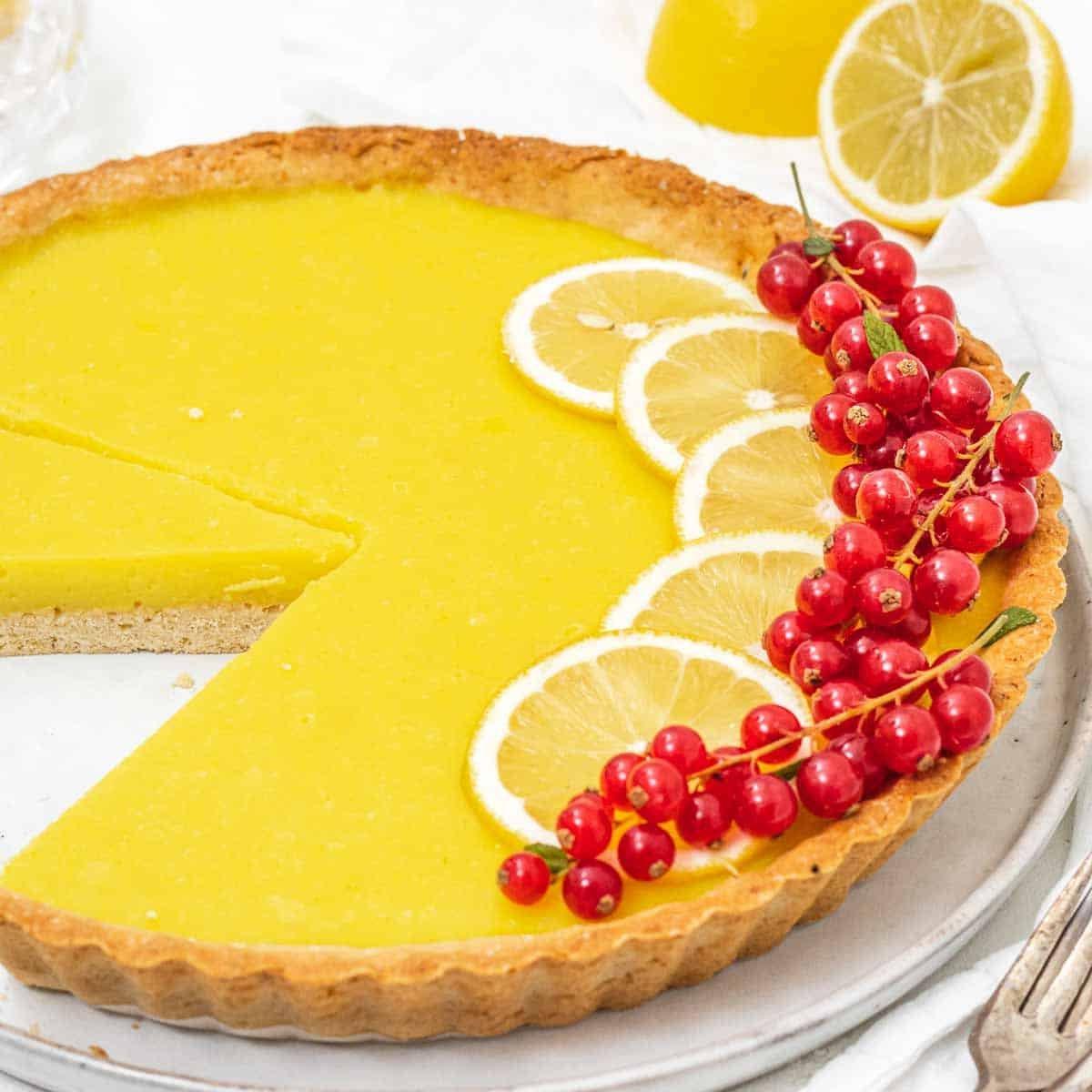 Köstliche vegane Zitronentarte mit frischen Zitronenscheiben.