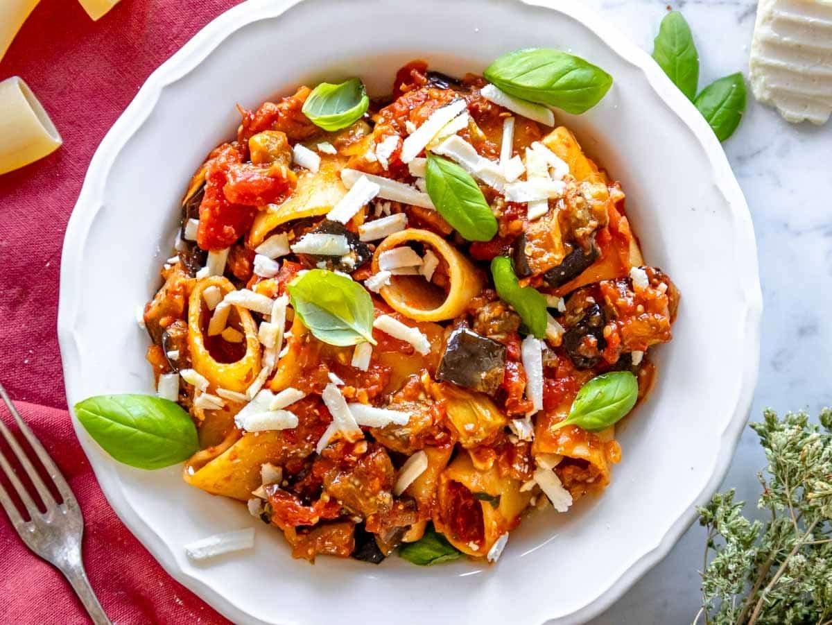 Auberginen-Pasta mit reichhaltiger Tomatensauce in einer weißen Schüssel.