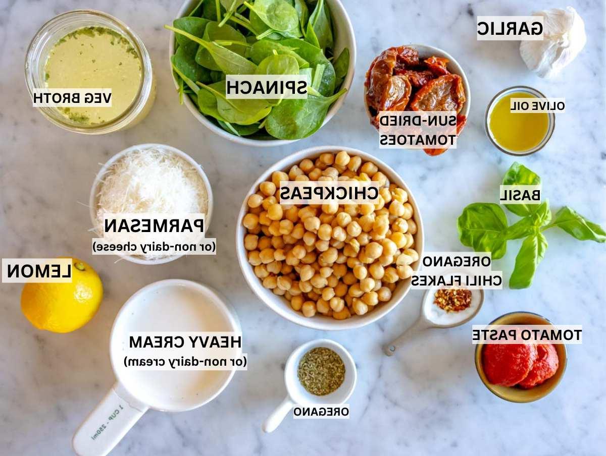 Zutaten für Marry Me Kichererbsen auf einem Marmortisch vorbereitet.