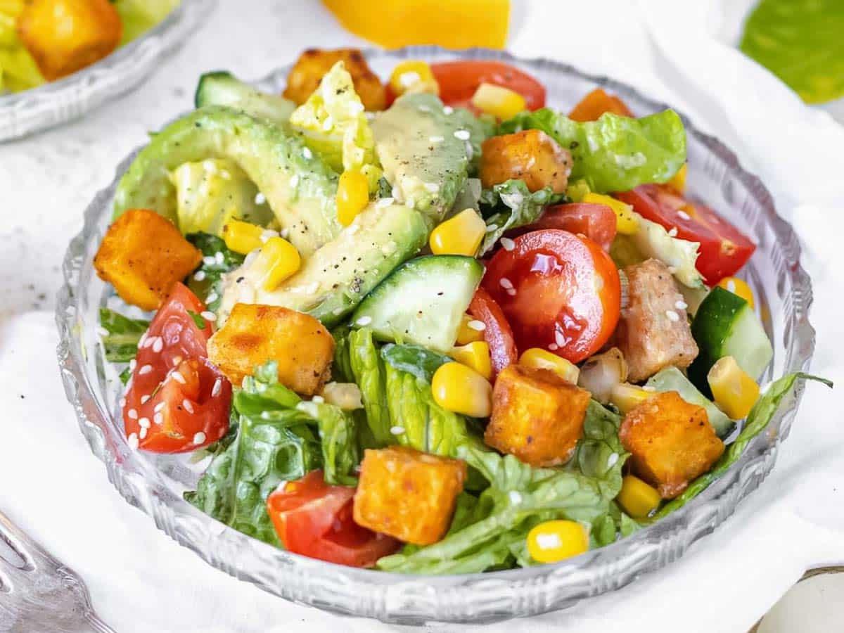 Tofusalat mit Avocado und Mais in einer modernen Schale angerichtet.