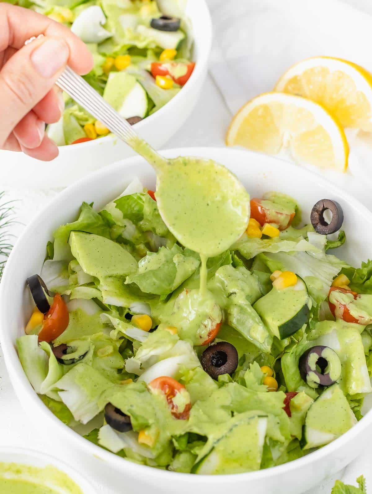 Grünes Göttinnen Dressing auf einem frischen Salat angerichtet