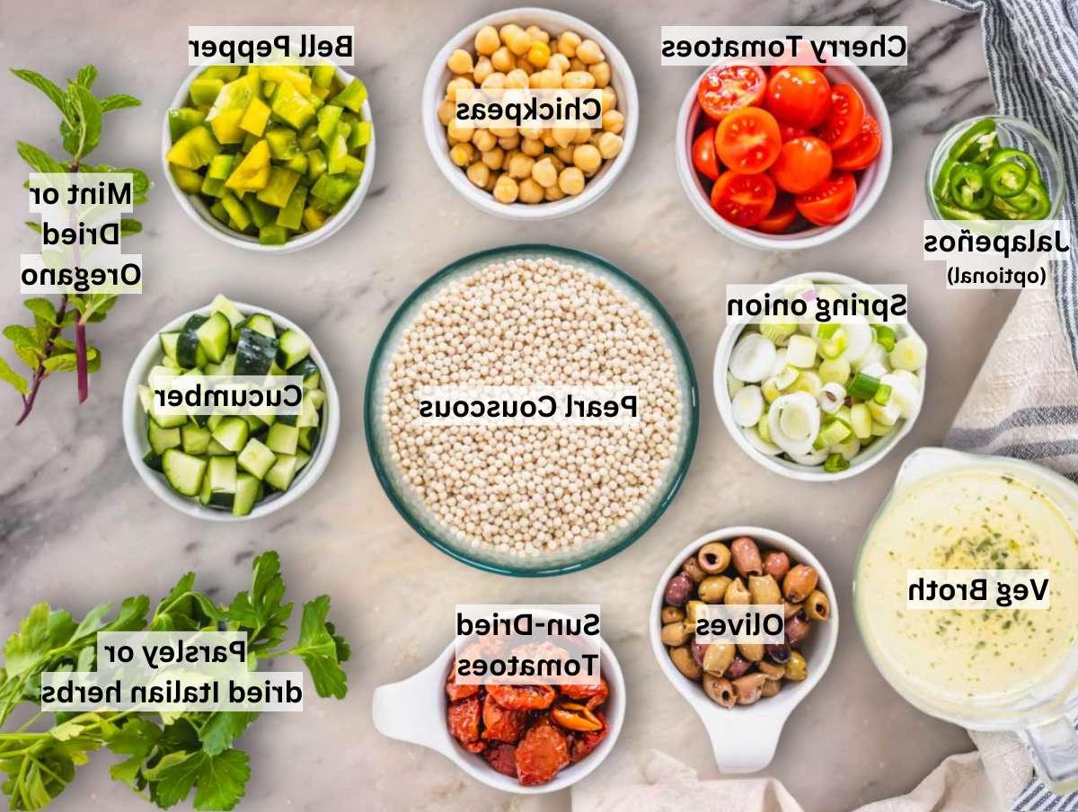 Zutaten für Perlcouscous Salat auf einem Marmortisch ausgebreitet.