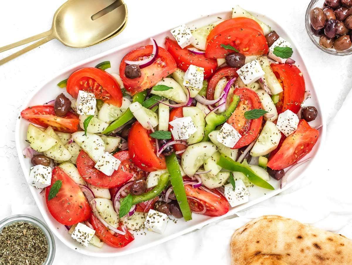 Griechischer Gurkensalat mit Pita-Brot auf einer Platte serviert