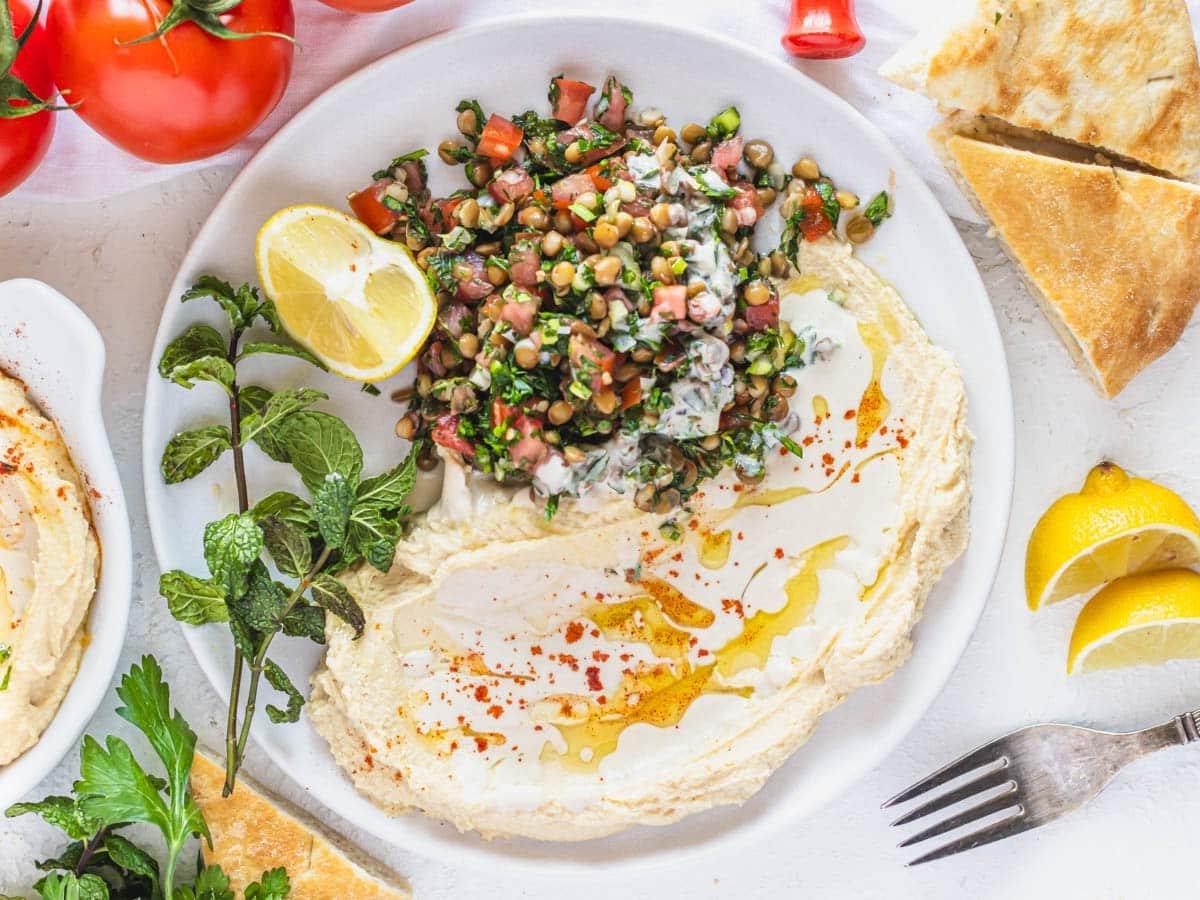 Linsen-Tabbouleh mit Hummus und Tahini-Sauce.