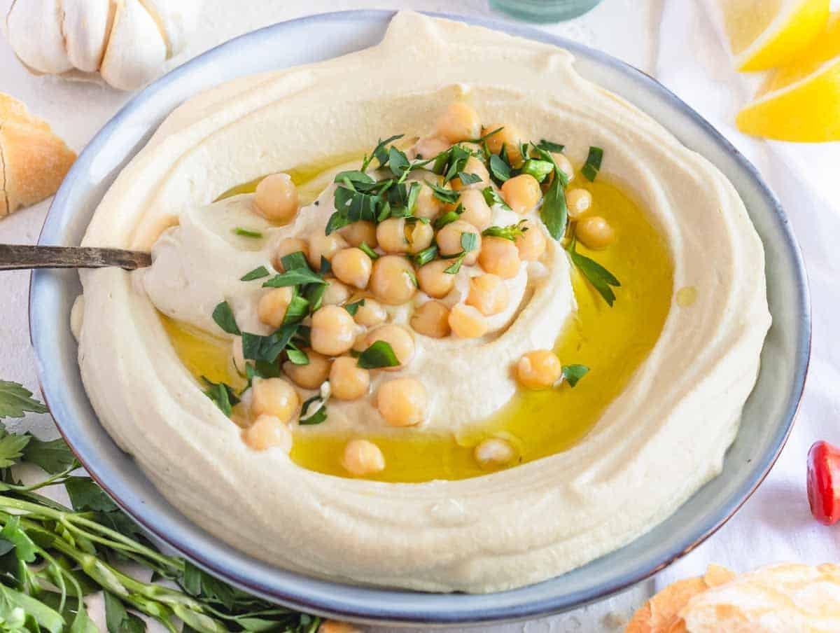 Hummus auf einem Teller mit einem silbernen Löffel