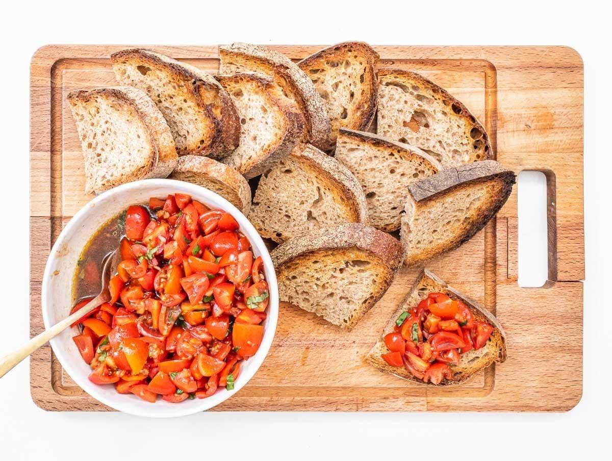 Bruschetta-Brot und Tomate auf einem Schneidebrett