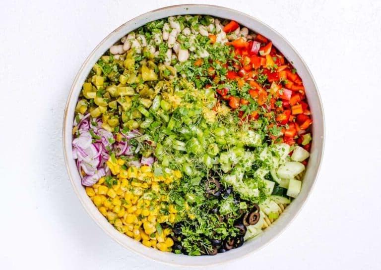 Cremiger Nudelsalat mit frischem und eingelegtem Gemüse in einer Schüssel.