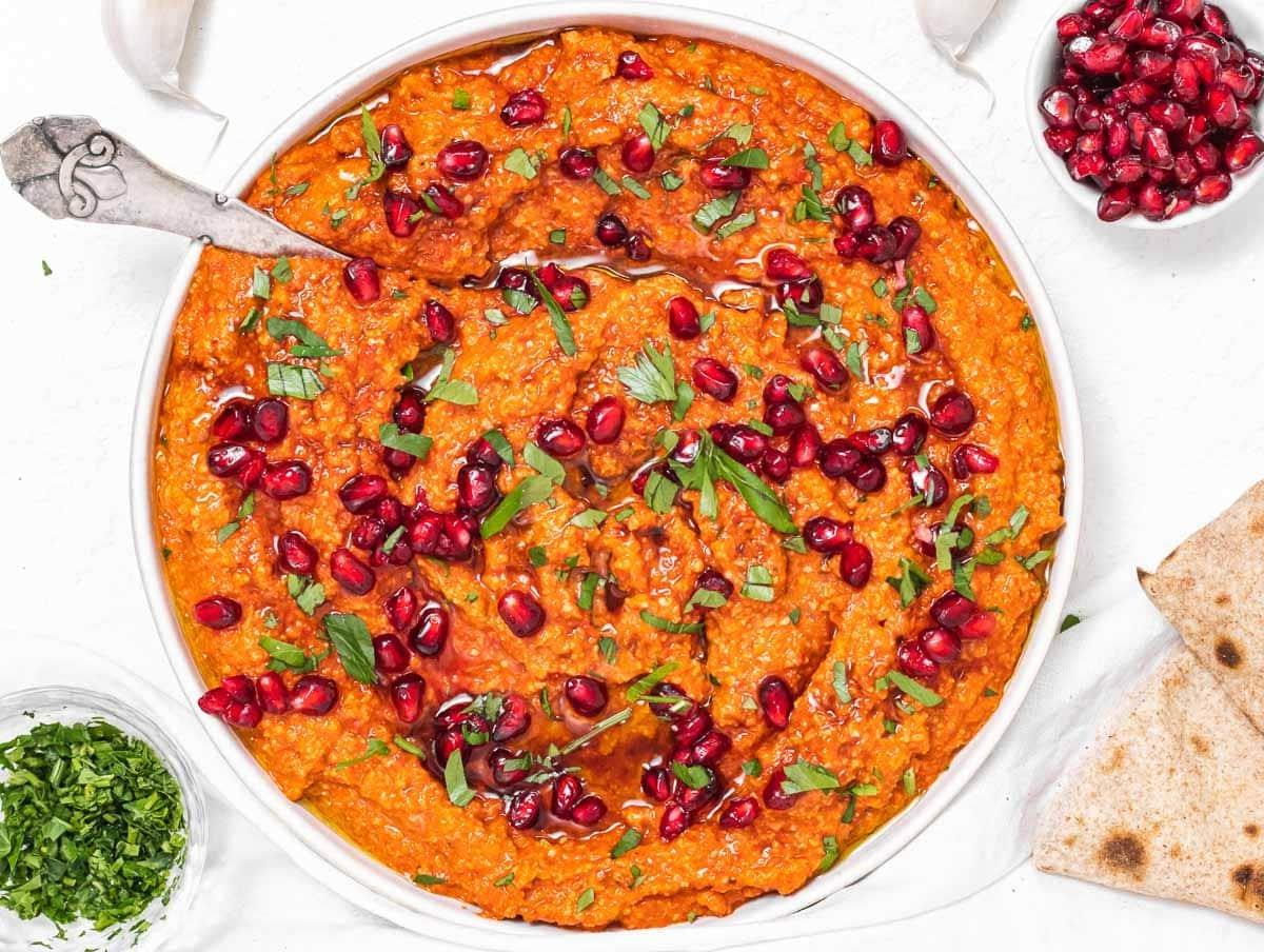 Muhammara mit Löffel und Petersilie