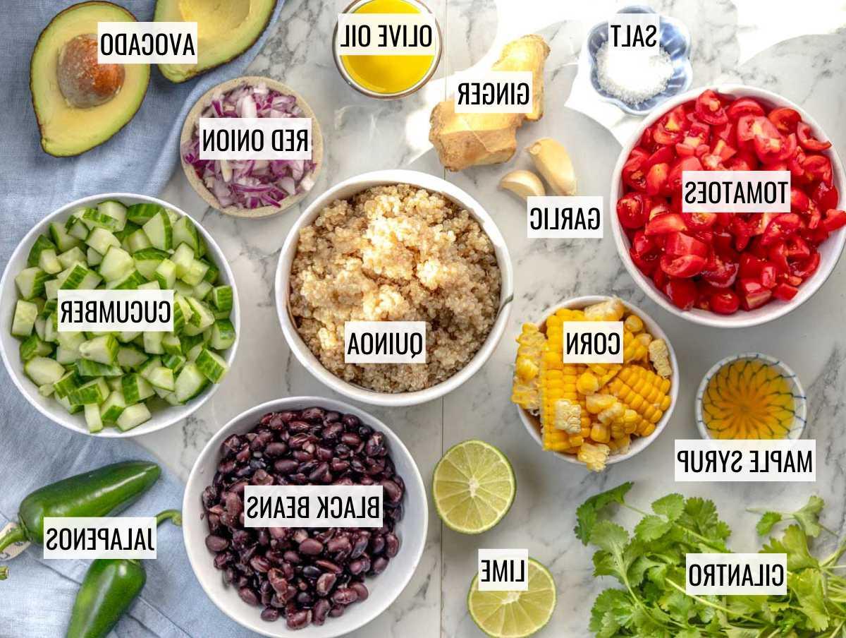 Zutaten für Quinoa Salat: Quinoa, Bohnen, Tomaten, Gurke, Mais, Zwiebel, Avocado, Koriander, Jalapeños und Limetten.