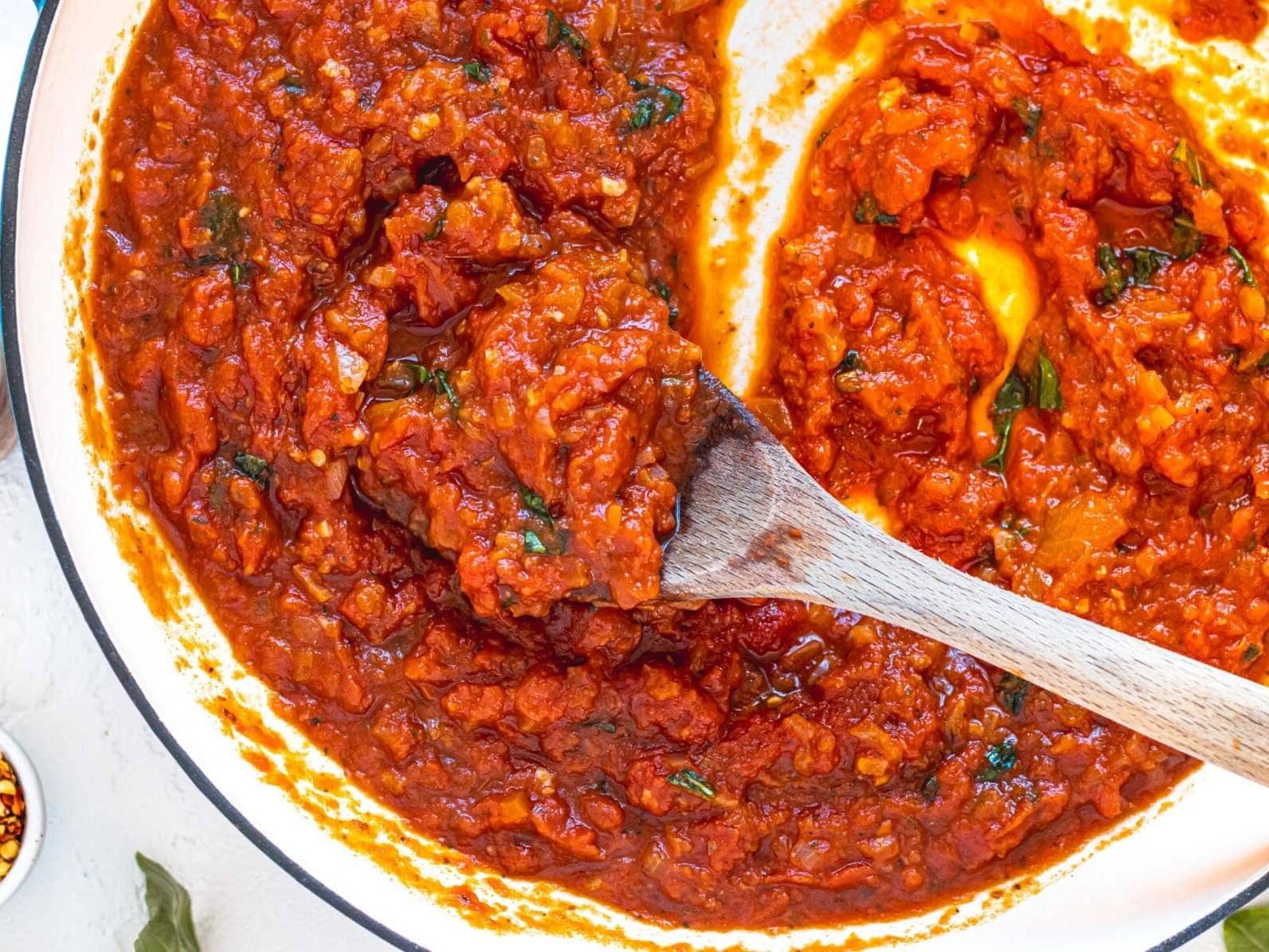 Marinara-Sauce in einer Pfanne mit einem Holzlöffel