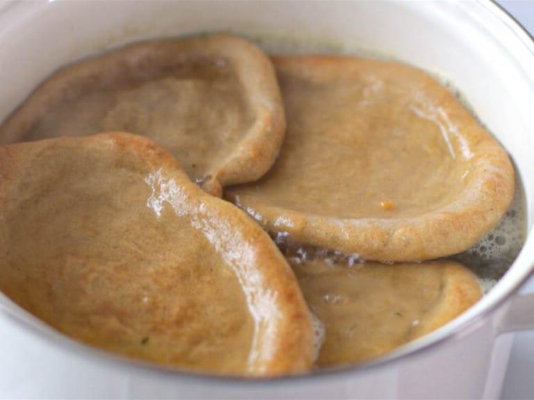Seitan-Stücke kochen in einem weißen Topf