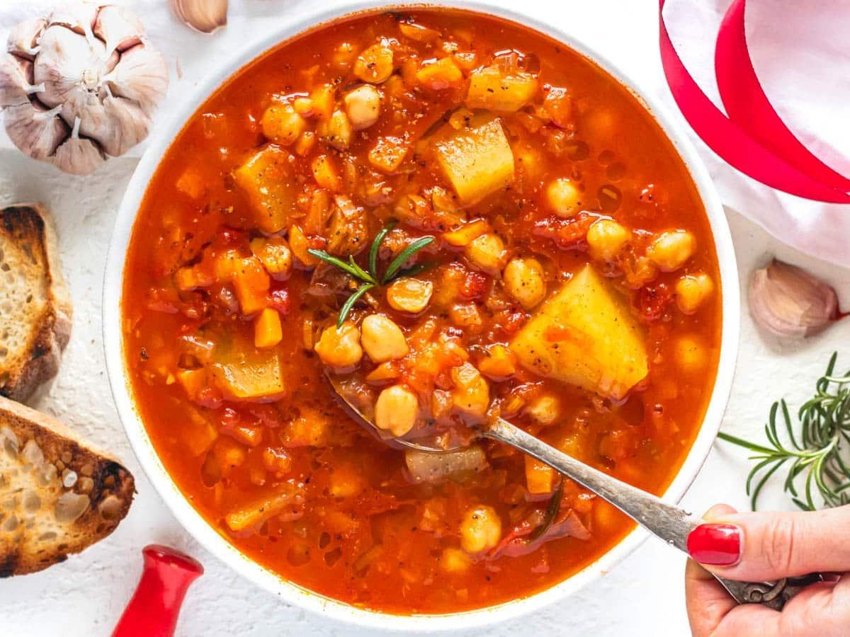 Kichererbsen-Suppe mit geröstetem Brot und Hand