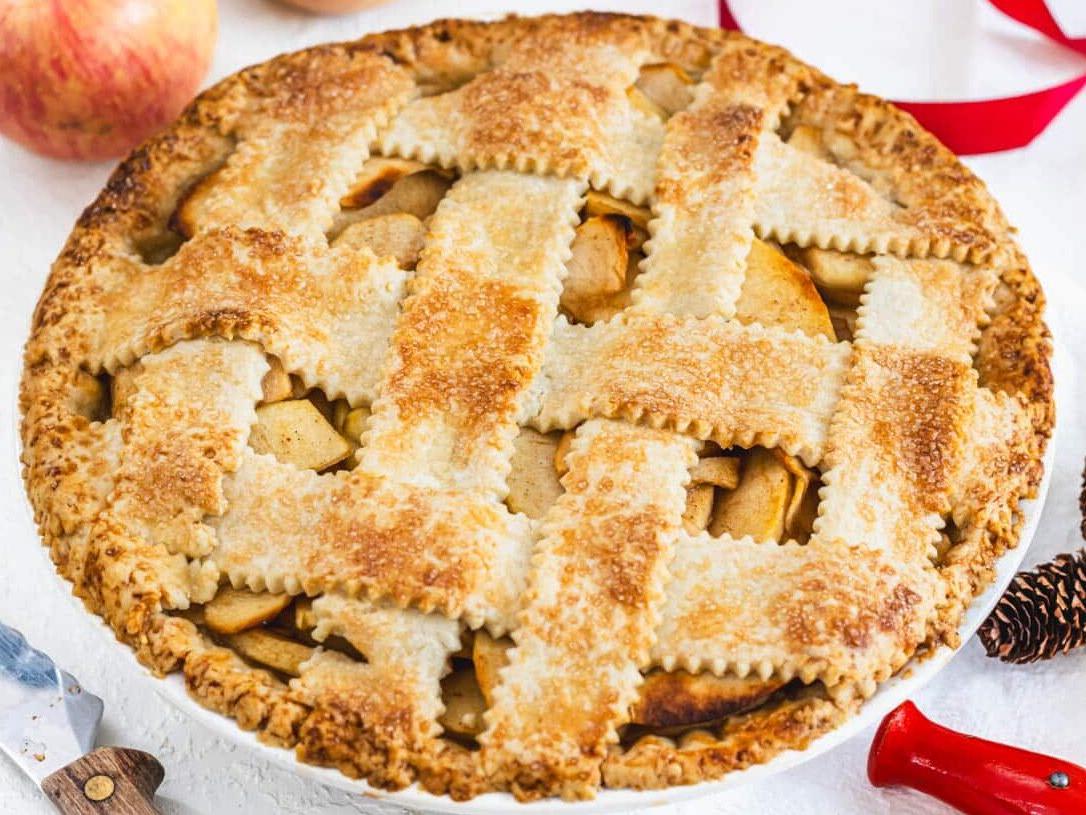 Veganer Apfelkuchen mit Messer und rotem Band