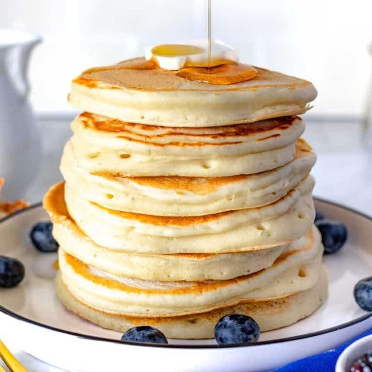 Vegane Pancakes mit Beeren und Ahornsirup.