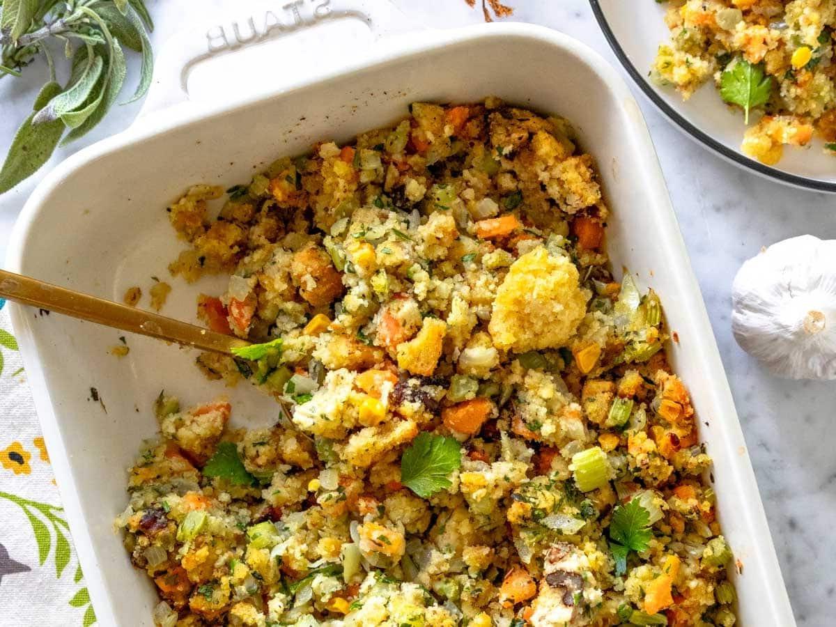 Cornbread Stuffing mit goldenem Löffel und frischen Kräutern