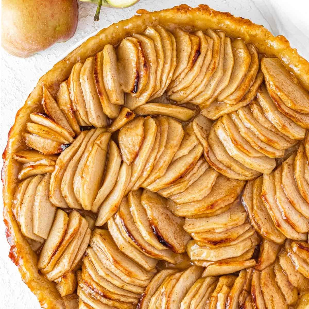 Goldbraune Apfeltarte mit geschichteten Apfelscheiben.