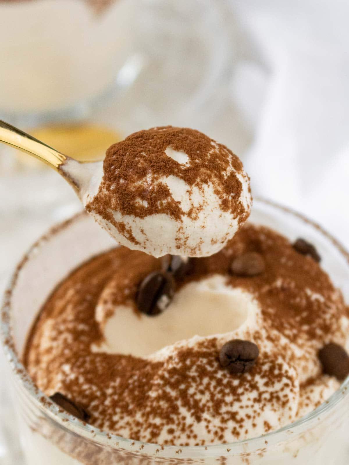 Löffel taucht in ein Glas mit Kaffee-Mousse