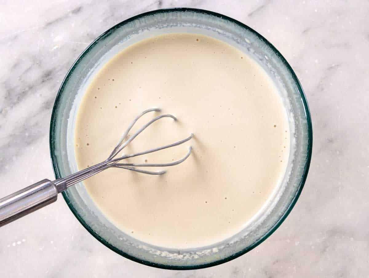 Tahini-Dressing nach dem Verquirlen in einer eleganten Glasschüssel serviert.