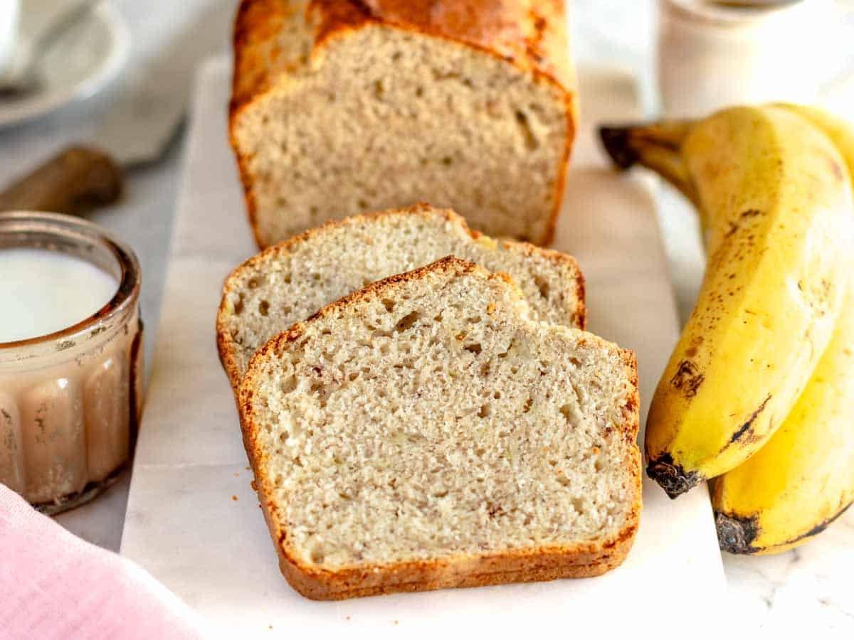 Zwei Scheiben veganes Bananenbrot auf einem Marmorbrett